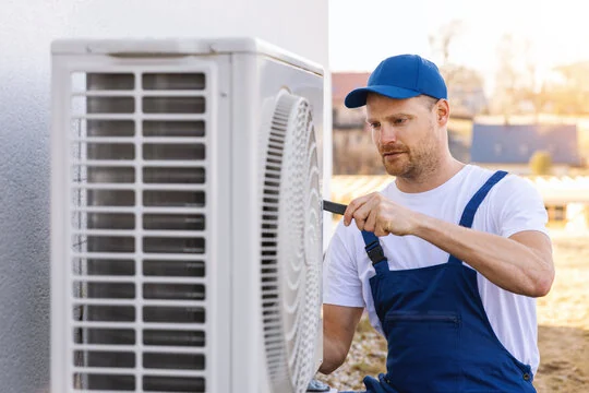 Technician inspecting an outdoor air-conditioning unit