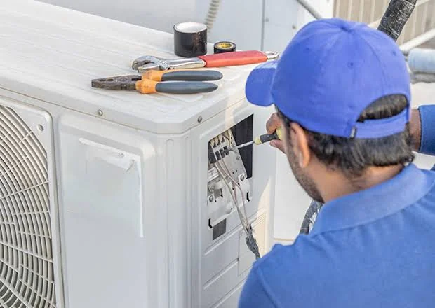 Technician checking an outdoor air-conditioner with service tools