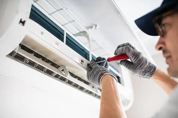 Technician inspecting the airflow components of a wall-mounted indoor unit